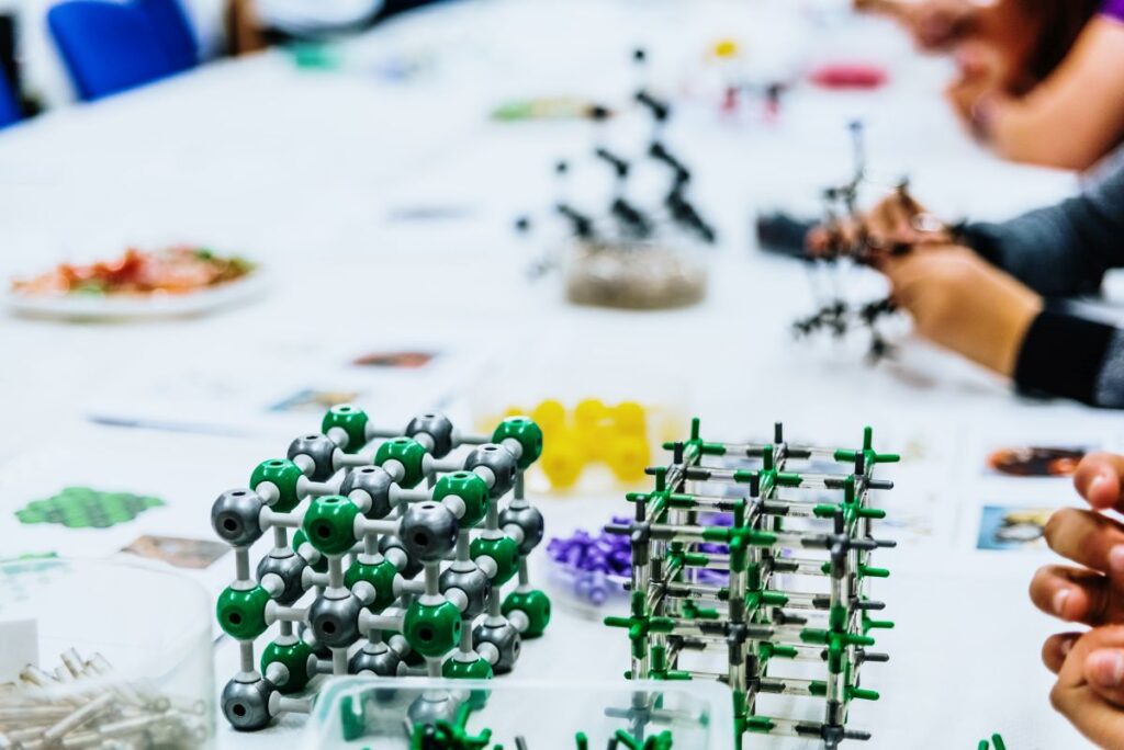 Group of students in biology class creating molecular models with educational toys.