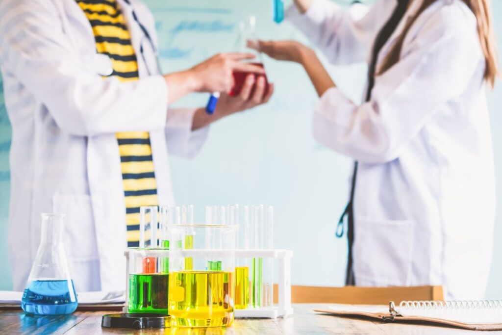 Couple of students working at chemistry class. Education concept